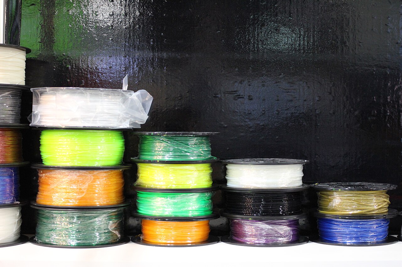 Real 3D printing filament spools stacked in a workshop
